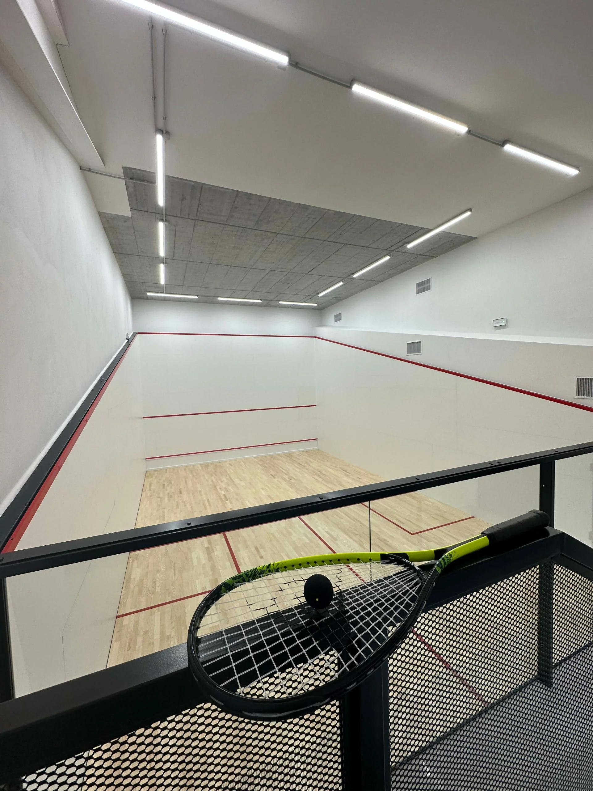 Squash court with racket and ball in the background